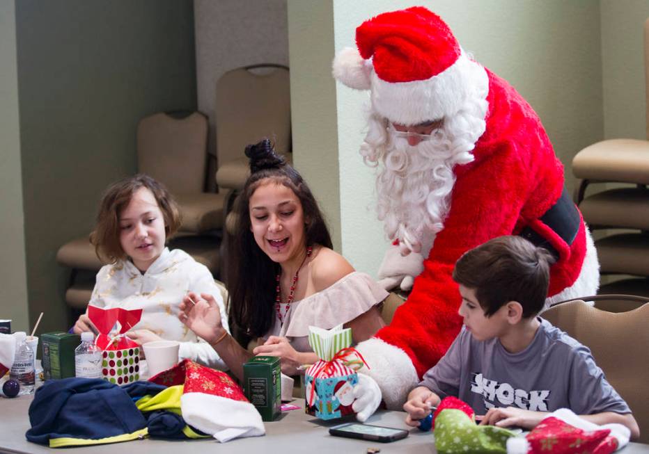 Santa Claus passes out gifts to survivors of the Alpine motel fire from left Brianna Aikens, 11 ...