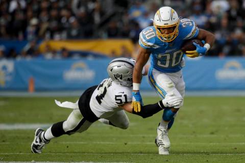 Los Angeles Chargers running back Austin Ekeler is tackled by Oakland Raiders inside linebacker ...