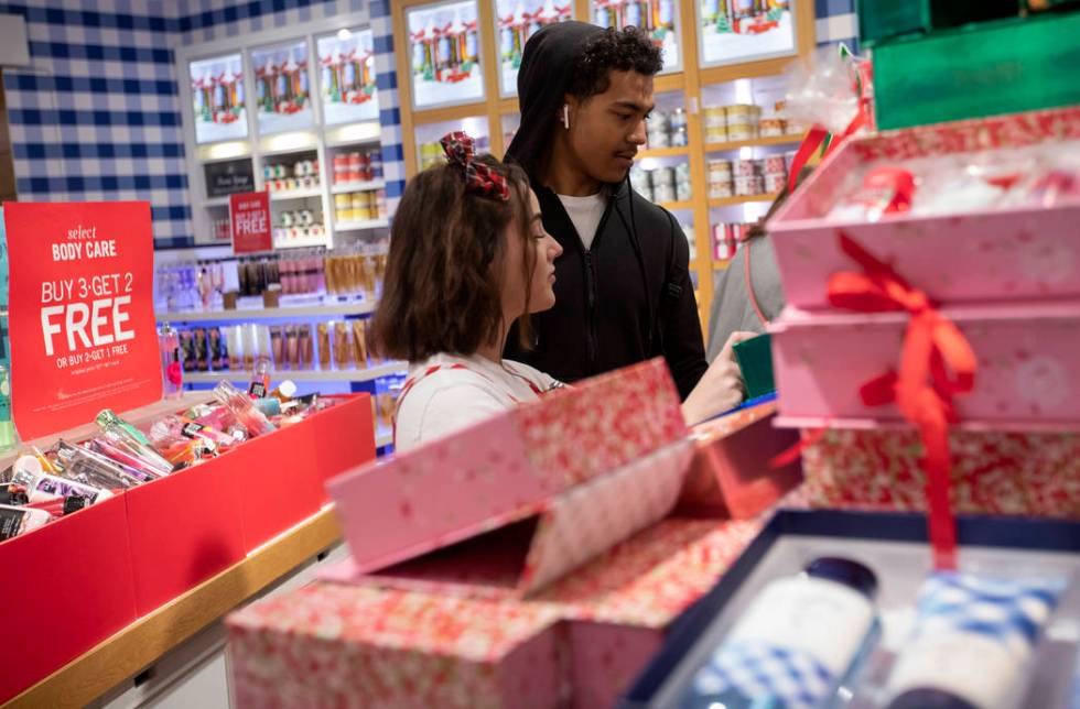 Bath and Body Works employee Caitlin Arias, left, helps customer Treshun Alexander, right, pick ...