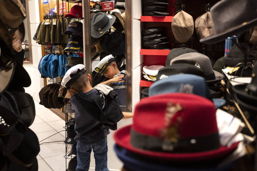 Eli Lombera, 7, of Bakersfield, Calif., checks himself in the mirror as he tries on hats at Hat ...