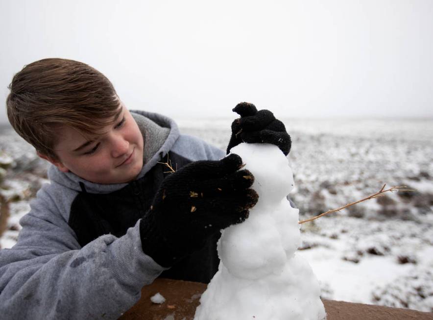 Jacob Luke, 14, of Las Vegas, makes a snowman at Red Rock Canyon Overlook on Thursday, Dec. 26, ...