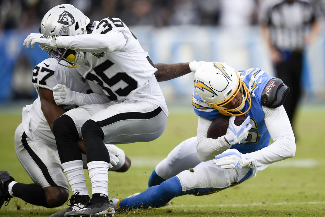 Oakland Raiders free safety Curtis Riley, middle, collides with teammate cornerback Trayvon Mul ...