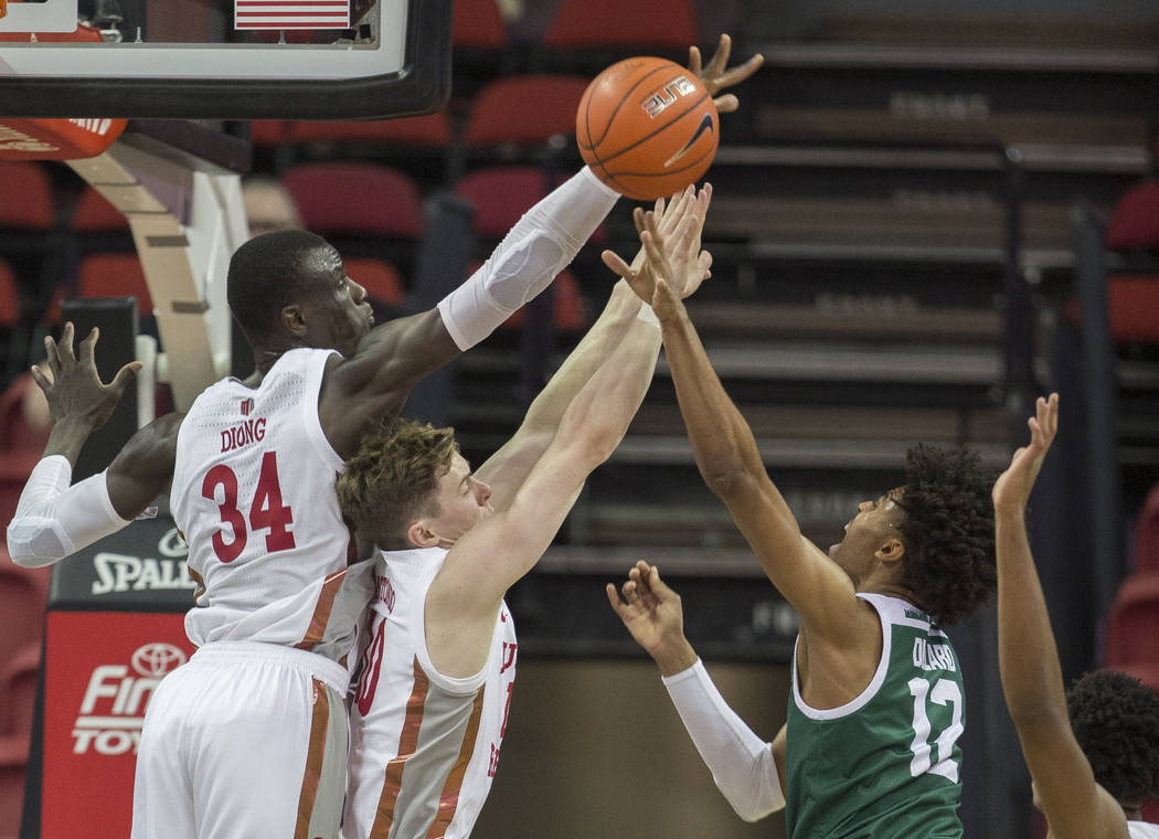 UNLV Rebels forward Cheikh Mbacke Diong (34) and UNLV Rebels guard Jonah Antonio (10) block the ...