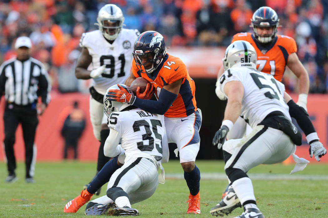 Oakland Raiders free safety Curtis Riley (35) tackles Denver Broncos wide receiver Courtland Su ...