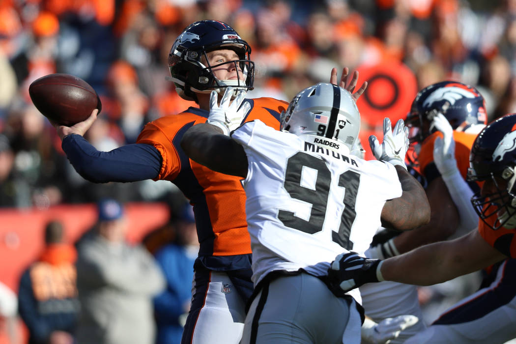 Denver Broncos quarterback Drew Lock (3) throws the football as Oakland Raiders defensive end B ...