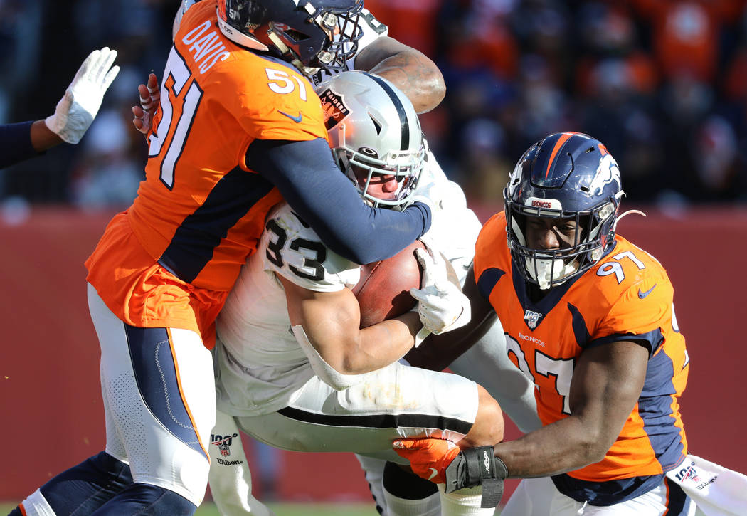 Oakland Raiders running back DeAndre Washington (33) is tackled by Denver Broncos inside lineba ...