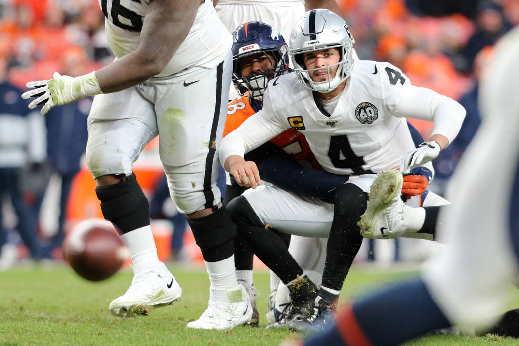 Oakland Raiders quarterback Derek Carr (4) looks at his pass fall incomplete as he is tackled b ...