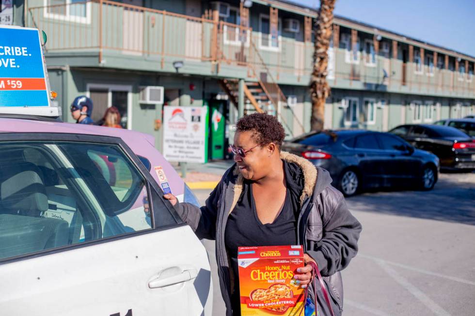 Alpine Motel tenant Tia Dotson gets into a complimentary taxi after a care package giveaway at ...