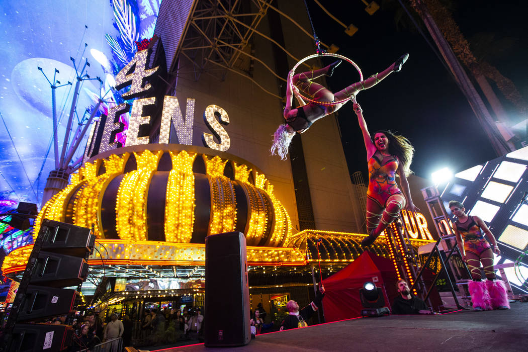 Aerialists perform on stage as New Year's Eve revelers gather at the Fremont Street Experience ...