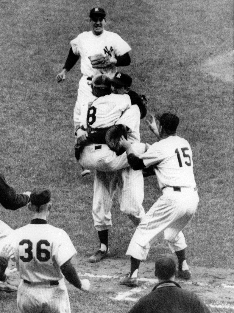 In this Oct. 8, 1956, file photo, New York Yankees catcher Yogi Berra (8) has jumped into the a ...