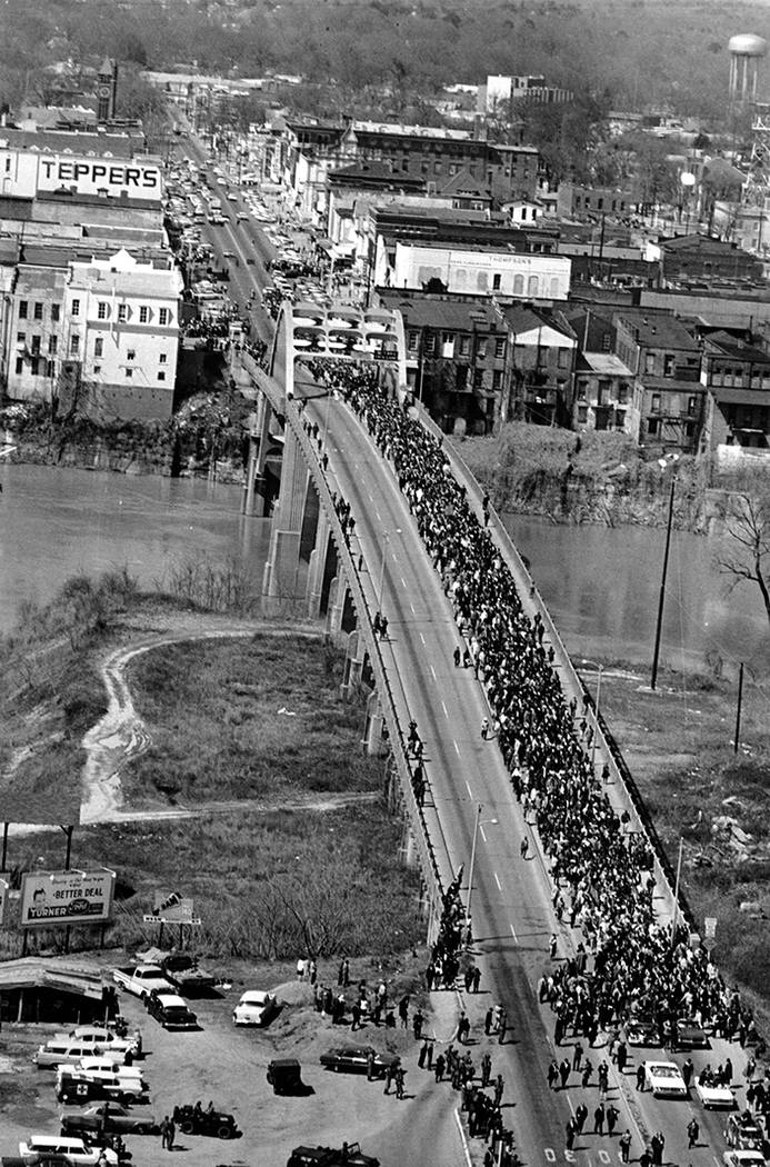 Marchers cross the Alabama river on the Edmund Pettus Bridge at Selma on March 21, 1965. The c ...