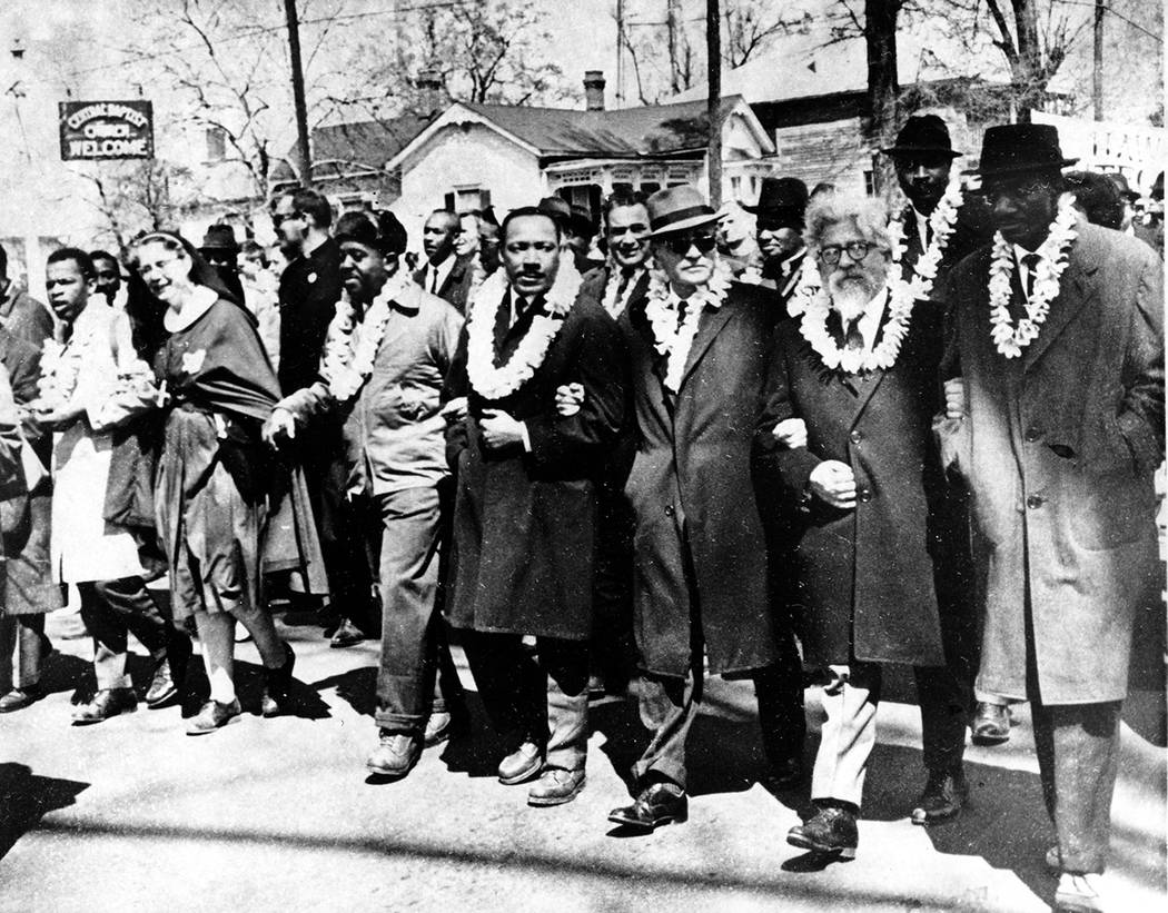 Dr. Martin Luther King Jr. links arms with other civil rights leaders as they begin the march t ...