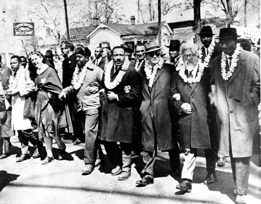 Dr. Martin Luther King Jr. links arms with other civil rights leaders as they begin the march t ...