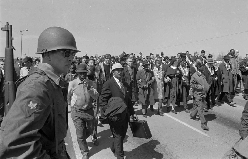 An armed soldier stands on duty at Selma Alabama, March 21, 1965 as civil rights marchers head ...