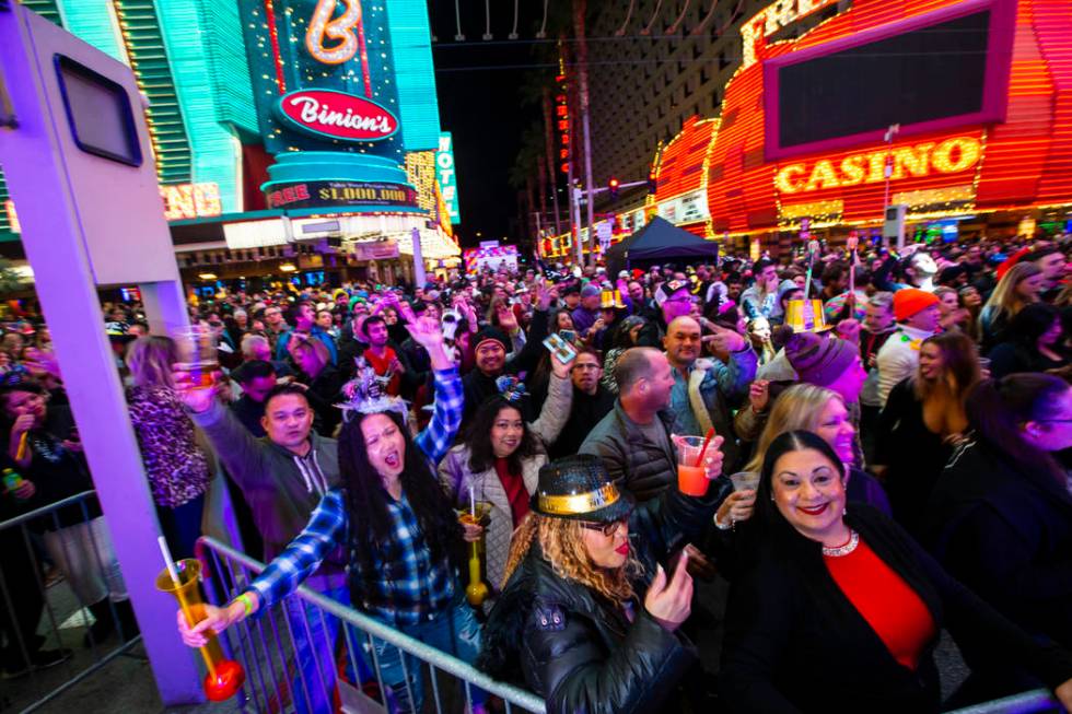 New Year's Eve revelers dance by a stage at the Fremont Street Experience in downtown Las Vegas ...