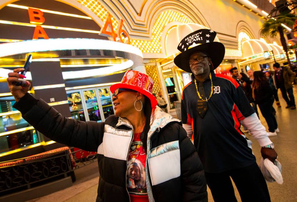 Kim Williams, left, takes a picture with Ronnie Renfroe, both of Detroit, as New Year's Eve rev ...