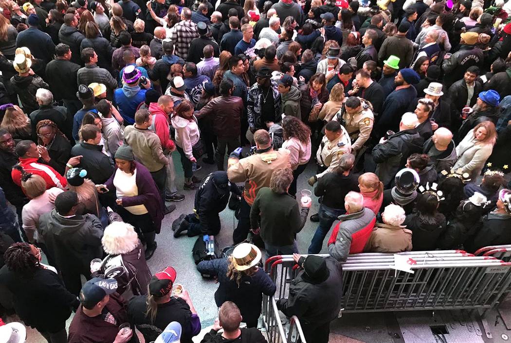 First responders assist a person who fell on Fremont Street during the New Year's Eve celebrati ...