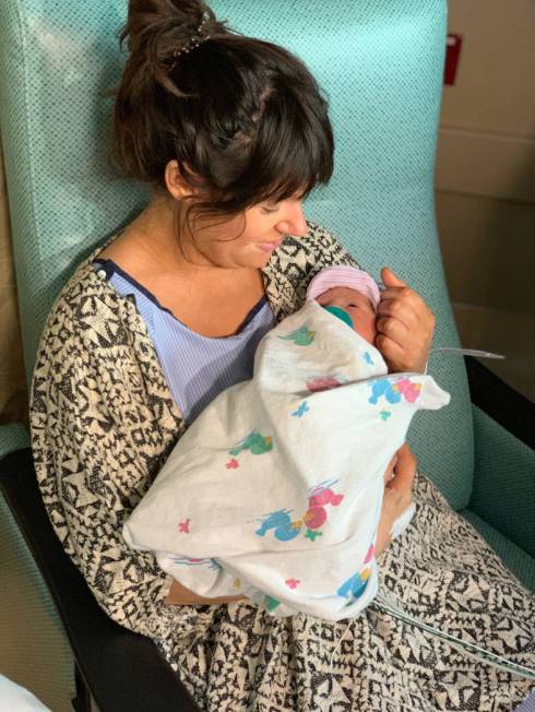 Marie Buckley holds her newborn son, Roman Black, who was born about one minute after midnight ...