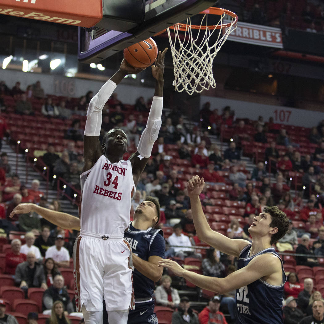 UNLV's forward Mbacke Diong shoots a point as Utah State's guard Diogo Brito (24) and center Tr ...