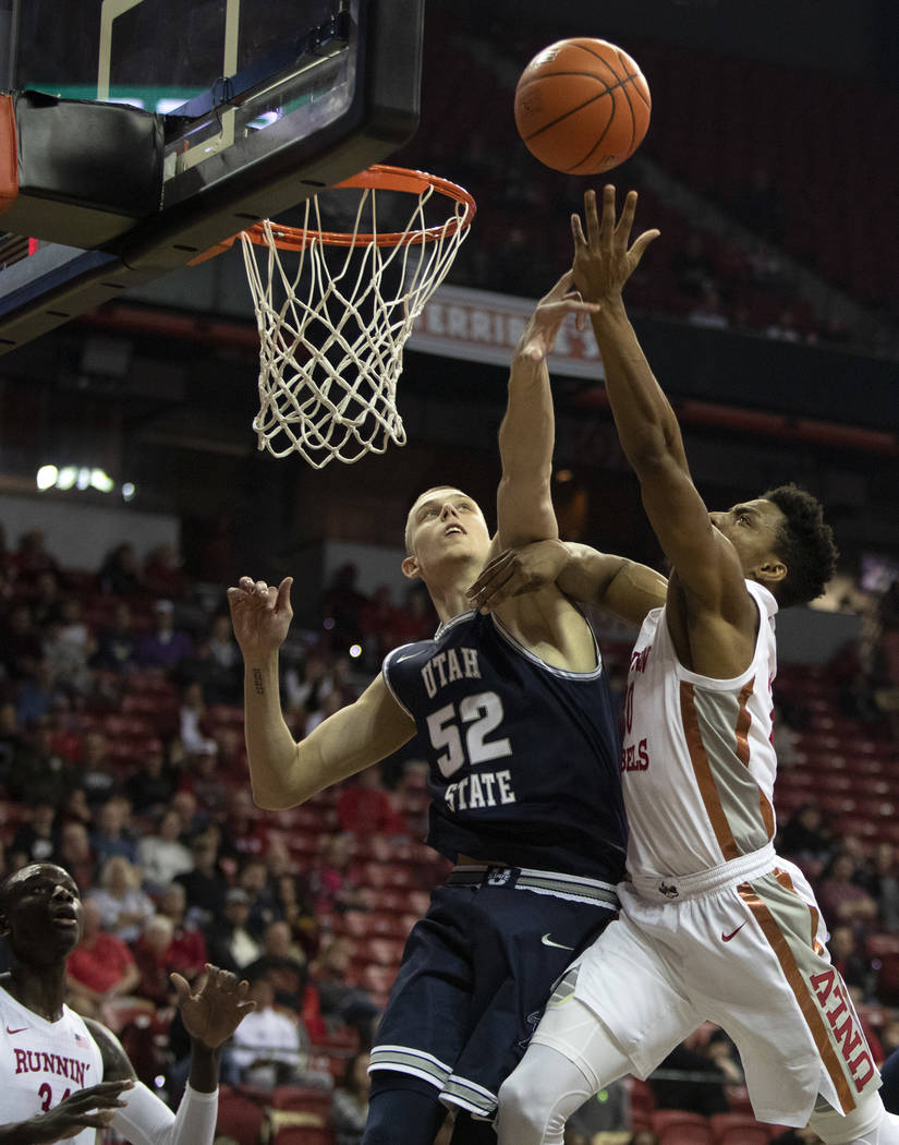 UNLV's forward Nick Blair (20) shoots a point as Utah State's center Kuba Karwowski (52) jumps ...