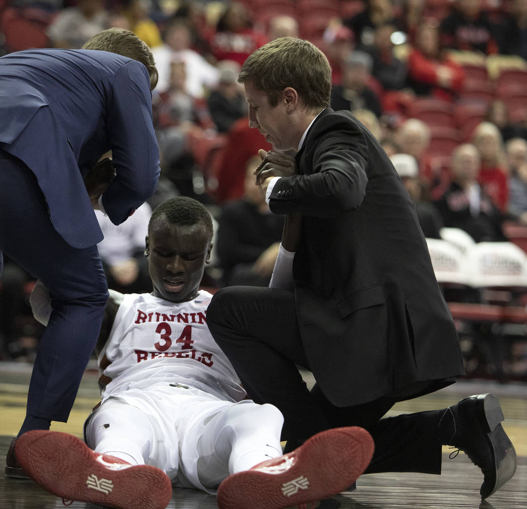 UNLV's forward Mbacke Diong (34) is pulled off the court by coaching staff during the first hal ...