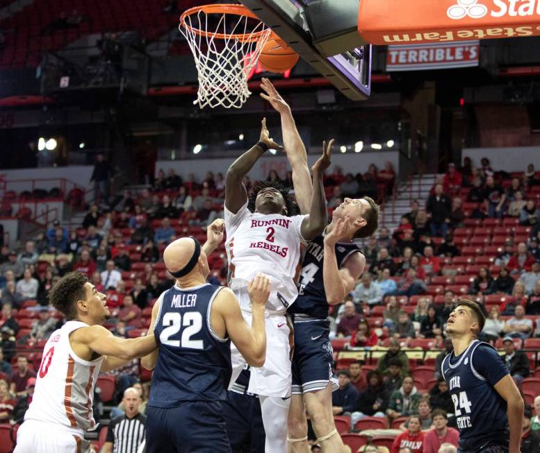 UNLV's forward Donnie Tillman (2) attempts a point as Utah State's forward Justin Bean (34) rea ...