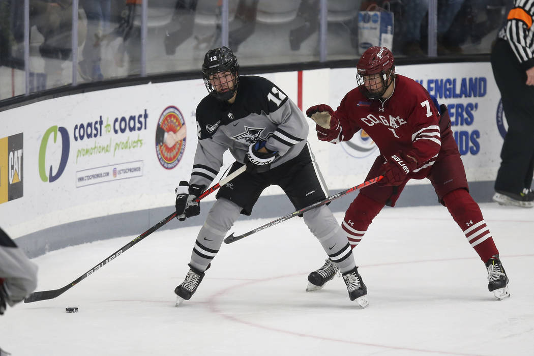 Providence's Jack Dugan (12) is defended by Colgate's Josh McKechney (7) during an NCAA hockey ...