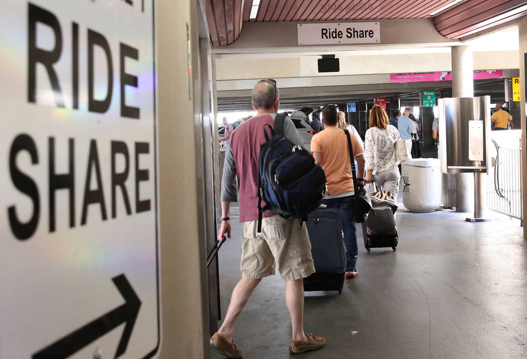 Riders arrive at Ride-hailing companies' Uber and Lyft pick up area at McCarran International A ...