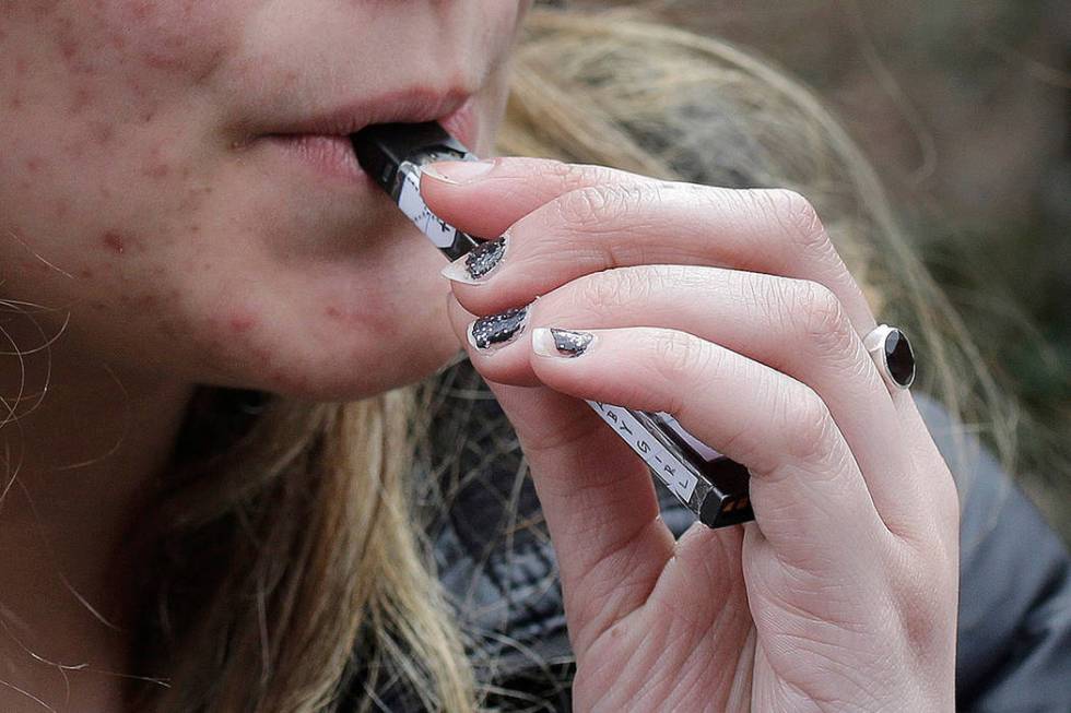 In this April 11, 2018, file photo, a 15-year-old high school student uses a vaping device near ...