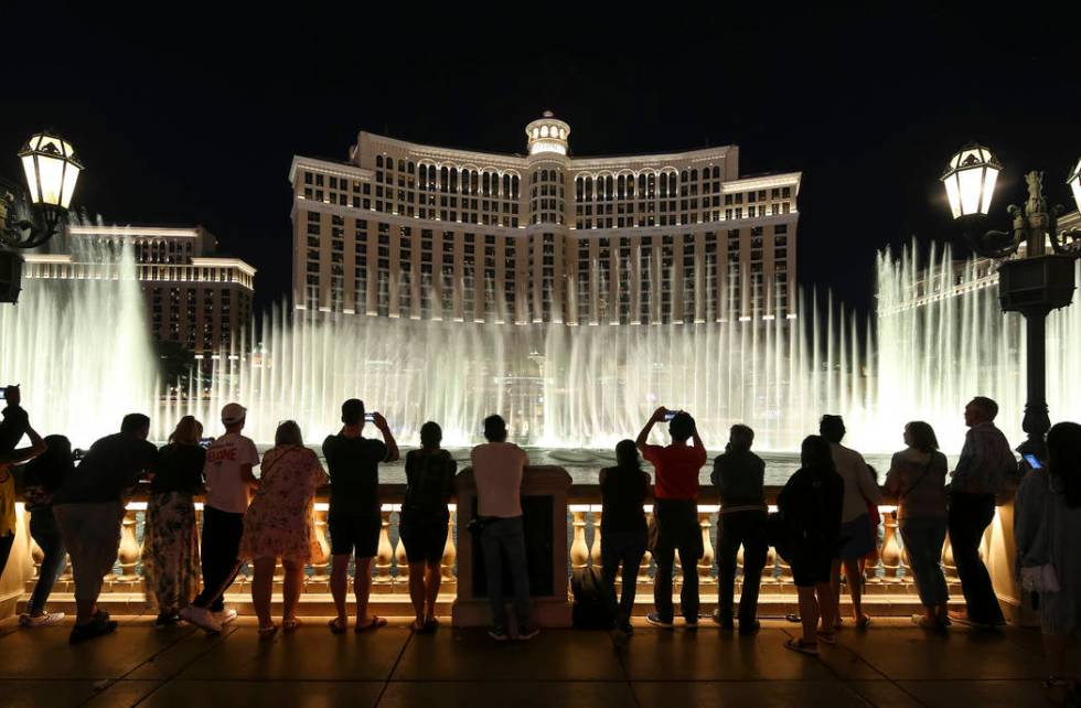 People watch the water fountain show outside the Bellagio hotel and casino on the Strip in Las ...
