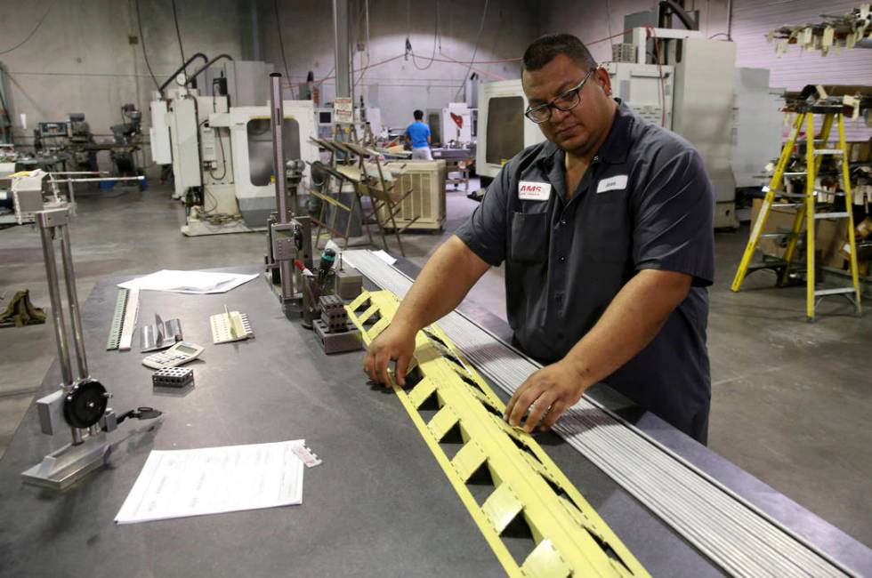 Facility Manager Jose Garcia shows a container release hinge with 70 individual hinges for a Bo ...