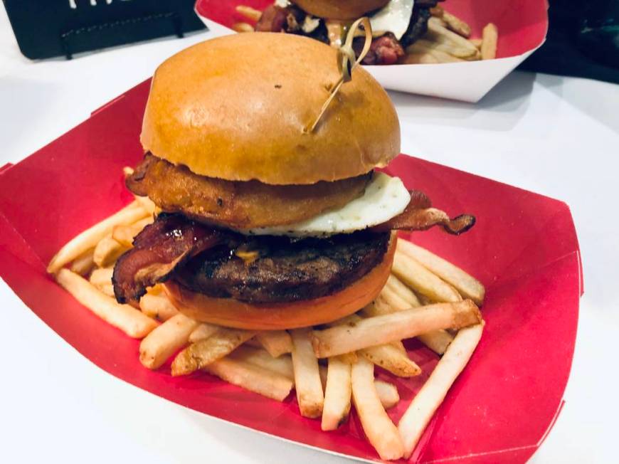 A Miyagi Burger from Bachi Burger includes bacon, a fried egg and onion rings, served alongside ...