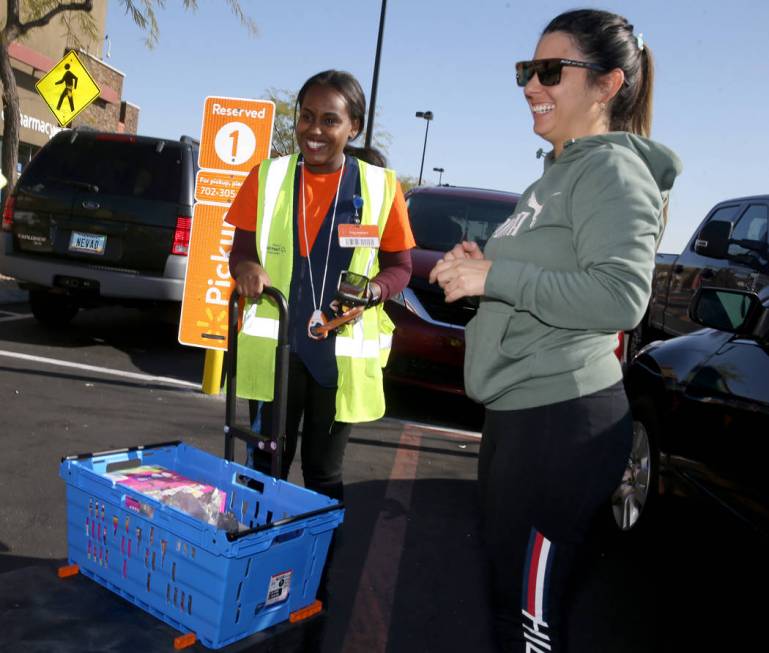 Personal shopper Mety Woldeyes, left, delivers merchandise to customer Raquel Lobato at Walmart ...