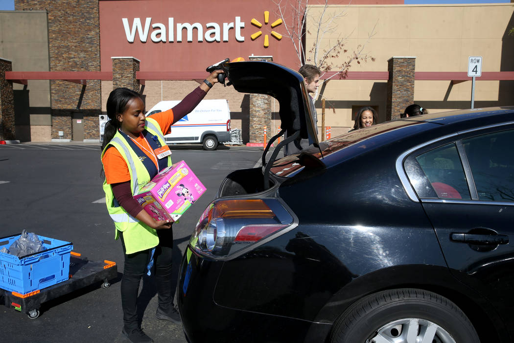 Personal shopper Mety Woldeyes loads a customer's curbside pickup order at Walmart at 7200 Arro ...