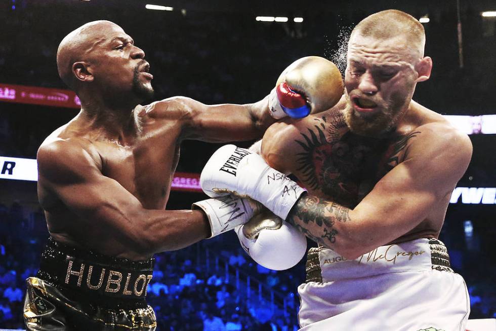 Floyd Mayweather, left, lands a left hook on the jaw of Conor McGregor on Saturday, Aug 26, 201 ...