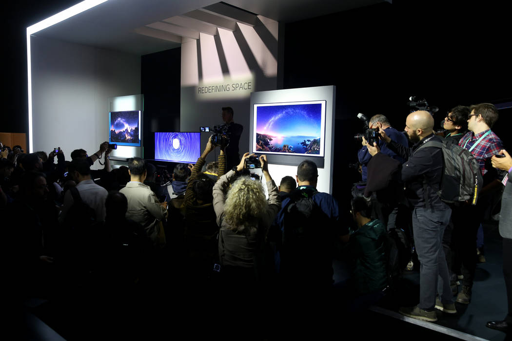 Members of the news media photograph new TVs, from Wallpaper TV, LG Signature OLED R TV, Galler ...