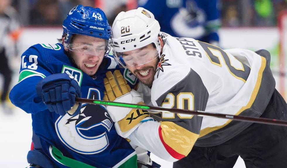 El defensor de los Vancouver Canucks, Quinn Hughes (43), compite por el control del puck contra ...