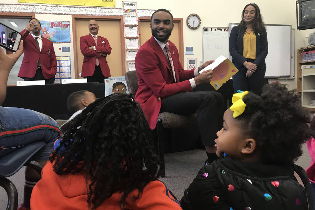 Evan Jackson Jr. with Kappa Alpha Psi reads to students at Booker Elementary School.