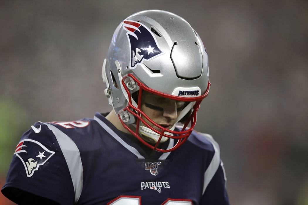 New England Patriots quarterback Tom Brady walks to the sideline after a series of plays in the ...