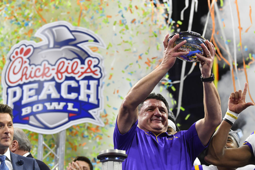 LSU coach Ed Orgeron holds the trophy after the team's Peach Bowl NCAA semifinal college footba ...