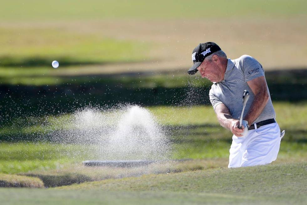 Gary Player hits out of a bunker onto the seventh green during the first round of the Father So ...