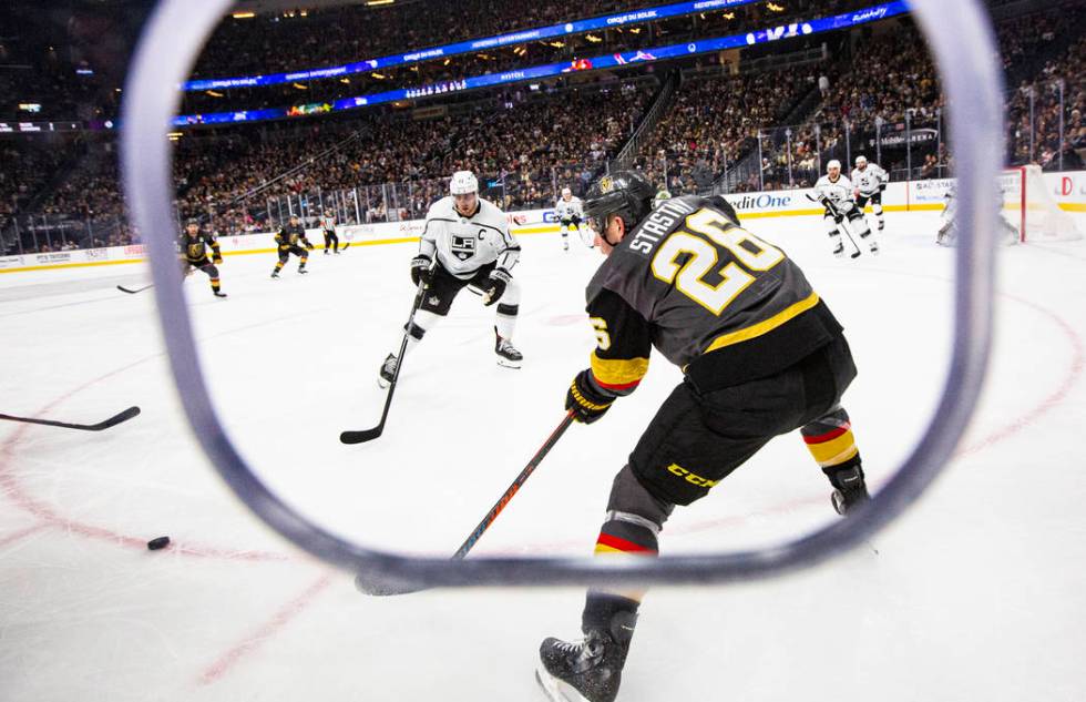 Golden Knights' Paul Stastny (26) sends the puck past Los Angeles Kings' Anze Kopitar (11) duri ...