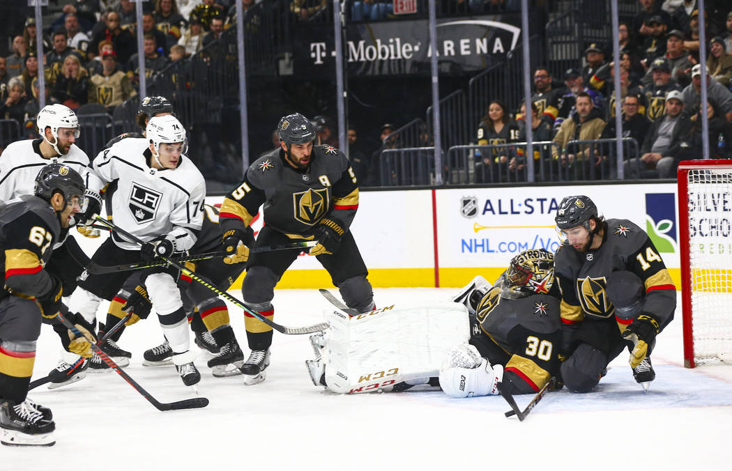 Golden Knights' Nicolas Hague (14) blocks a rebound shot from Los Angeles Kings' Nikolai Prokho ...