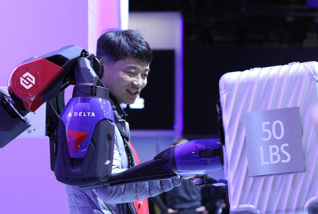 Hongki Yoo of South Korea, using upper-body exoskeleton, lifts a 50 lb suitcase at Delta Airlin ...