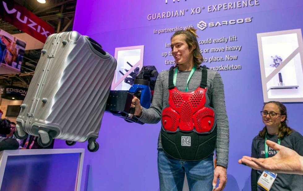 Sam Landa lifts a 50 lb suitcase with the aid of a Sarcos Guardian XO Exoskeleton during CES Da ...