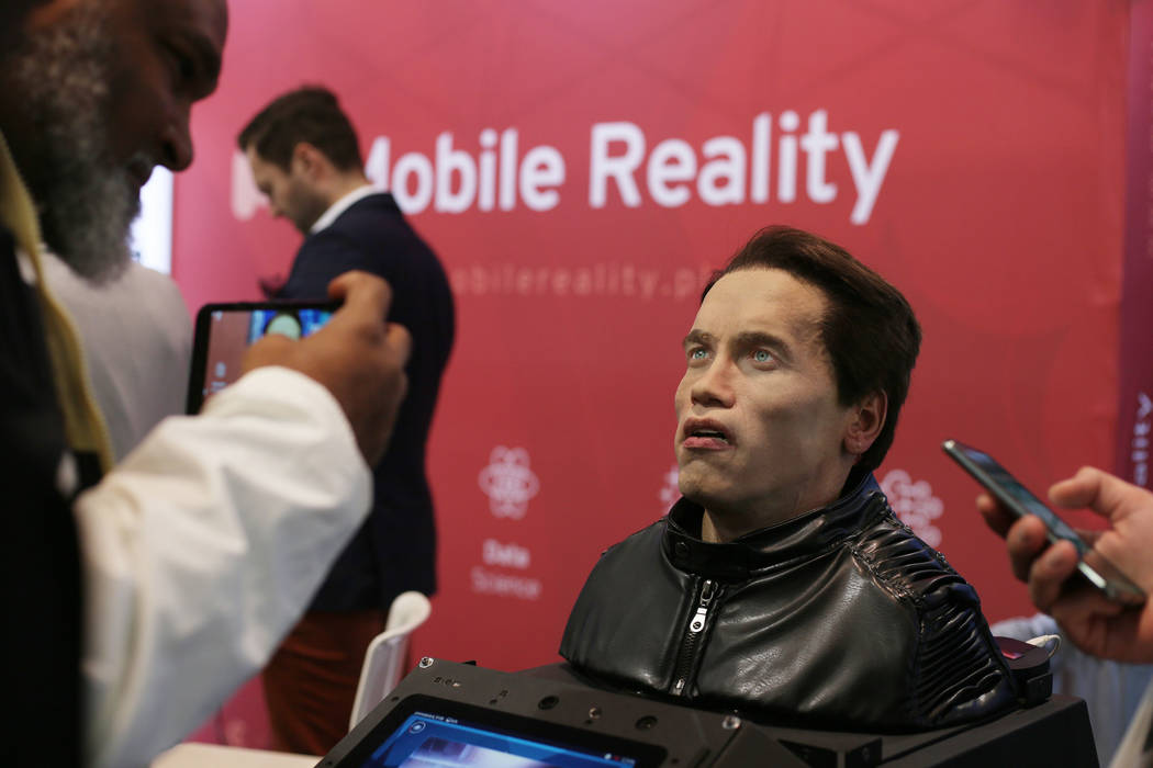 CES attendees record the animatronic bust of Arnold Schwarzenegger introduced by Promobot at th ...