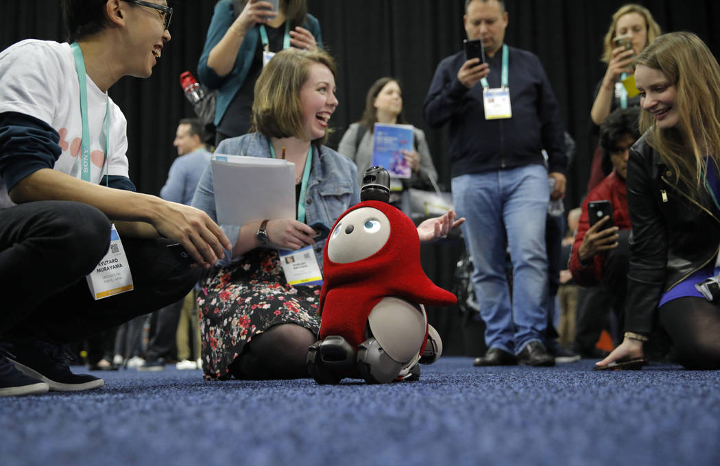 People interact with a Lovot robot during CES Unveiled before CES International, Sunday, Jan. 5 ...