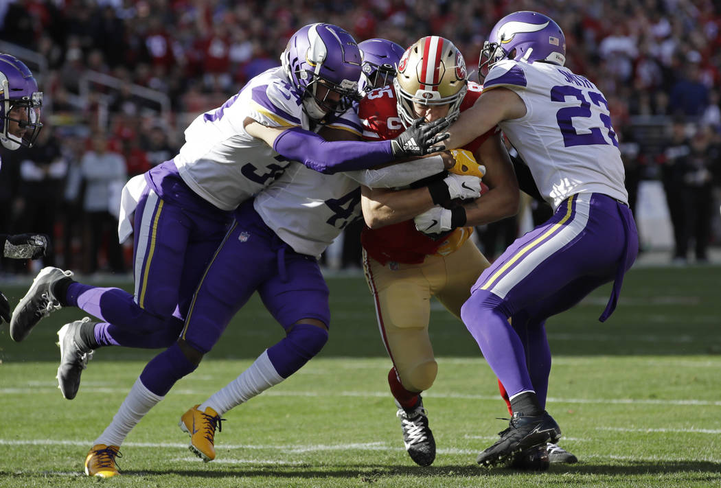 San Francisco 49ers tight end George Kittle, center, is tackled by Minnesota Vikings Minnesota ...