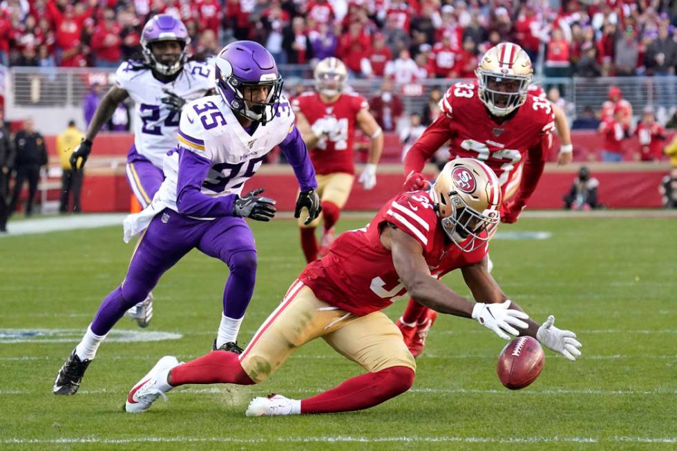 San Francisco 49ers' Raheem Mostert, lower right, recovers the ball after Minnesota Vikings' Ma ...