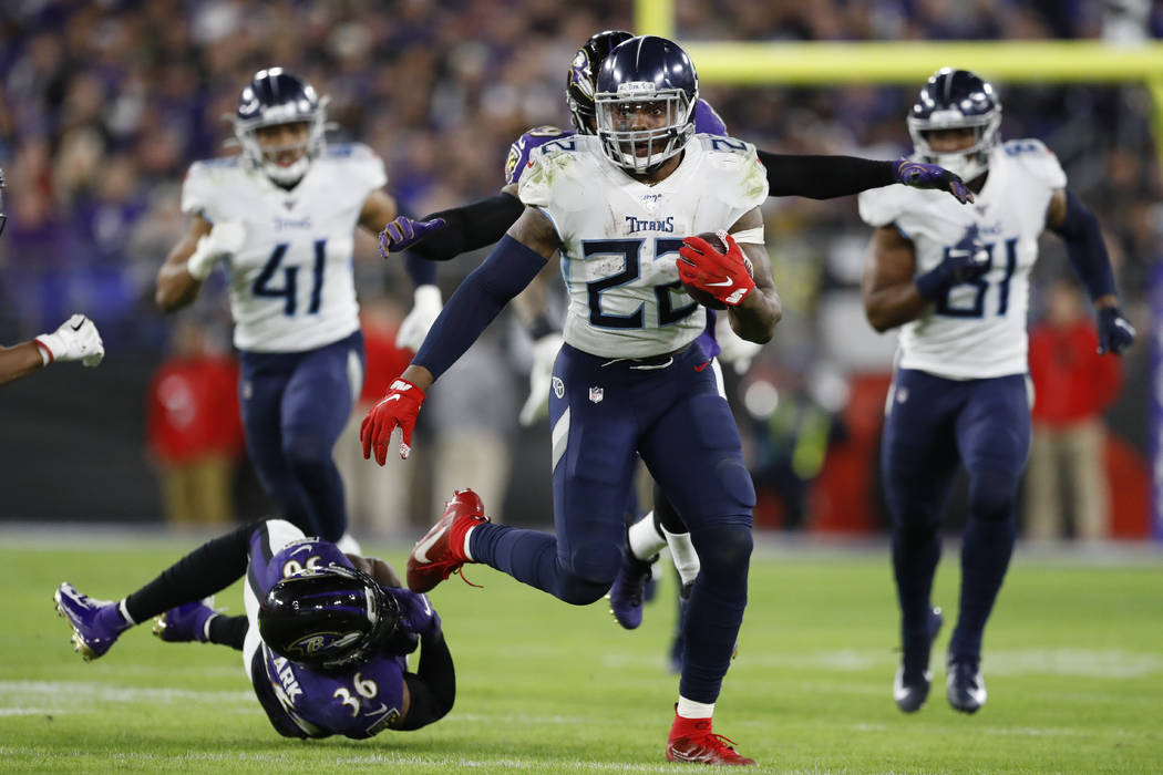 Tennessee Titans running back Derrick Henry (22) runs past Baltimore Ravens strong safety Chuck ...